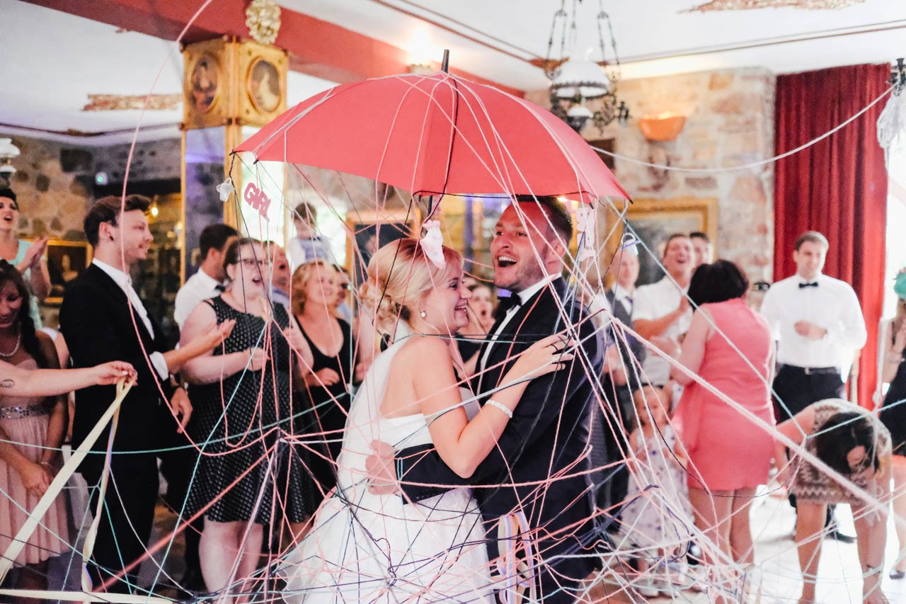 Hochzeitspaar jubelt im Cabriolet