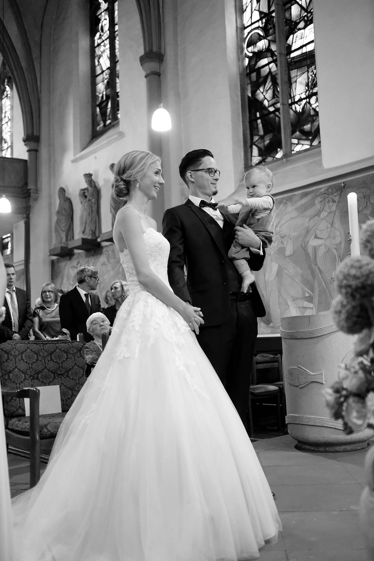 Hochzeitspaar jubelt im Cabriolet