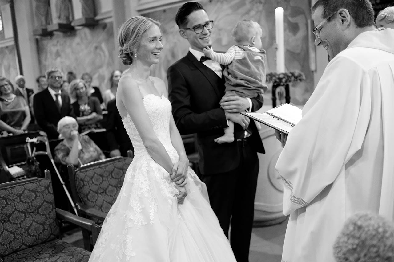 Hochzeitspaar jubelt im Cabriolet