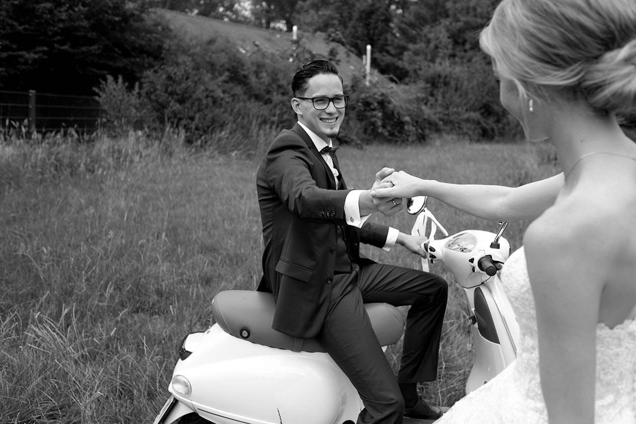 Hochzeitspaar jubelt im Cabriolet