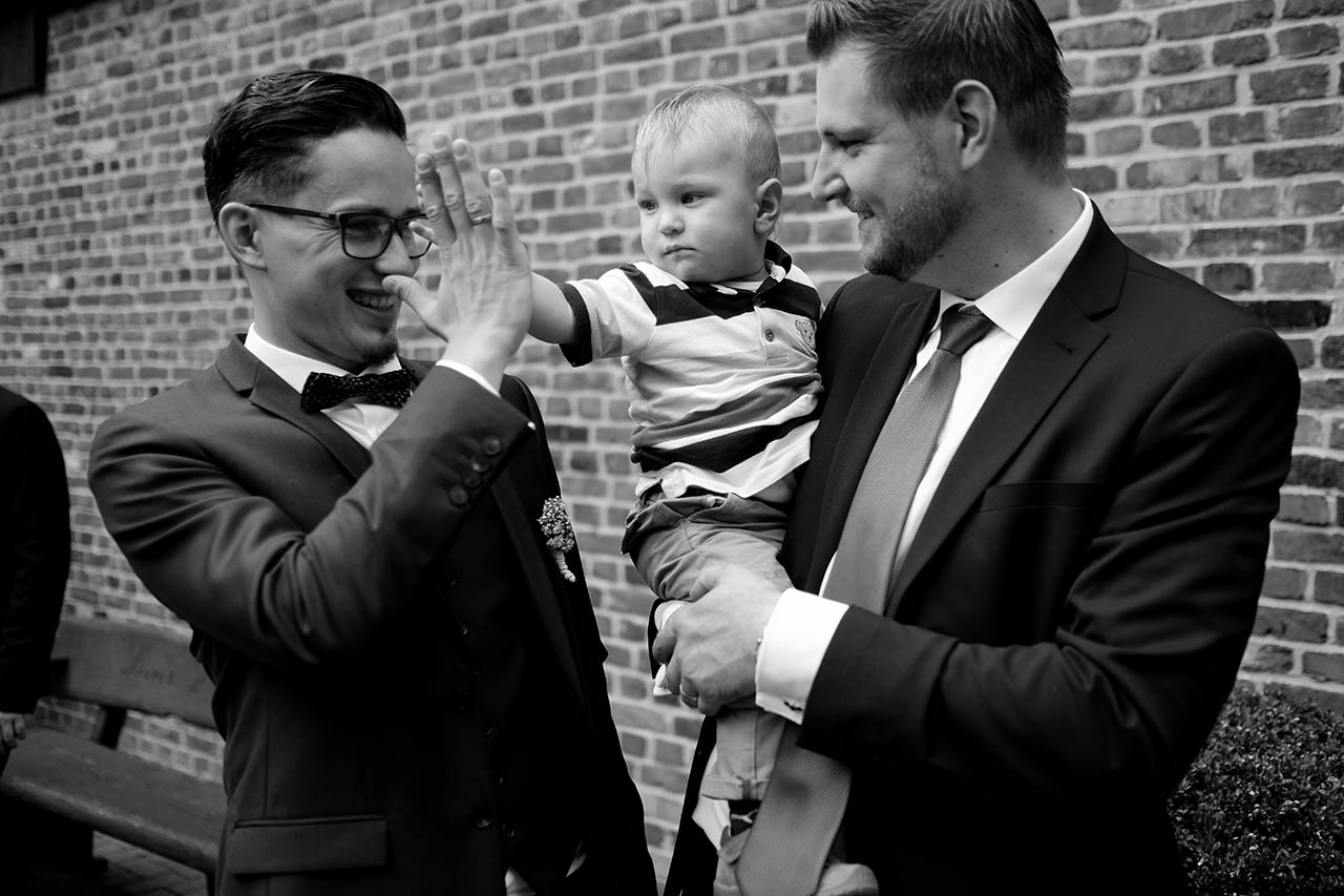 Hochzeitspaar jubelt im Cabriolet